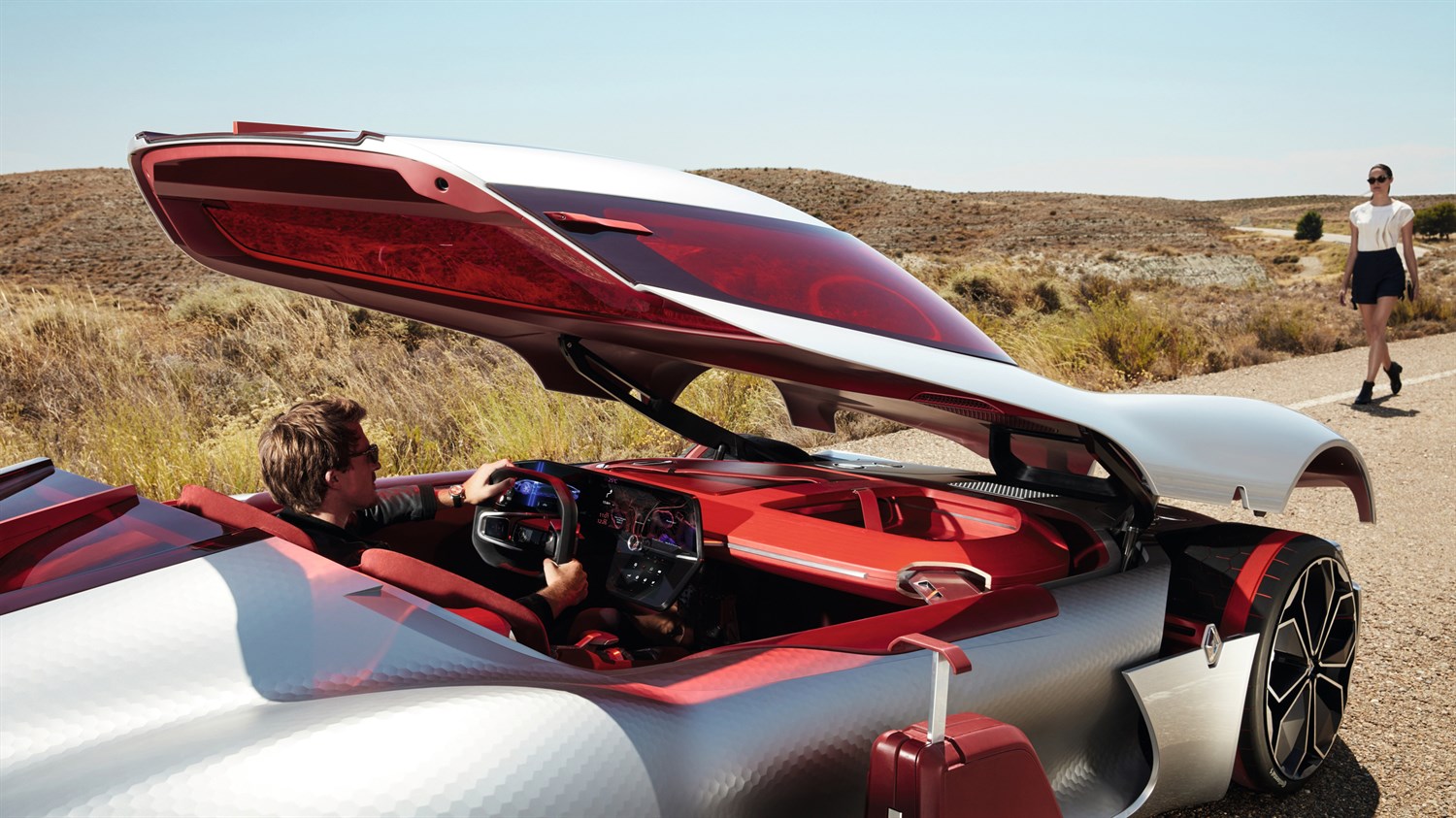 Renault TREZOR Concept - un homme assis au volant du véhicule ouvert - une femme marchant vers le véhicule 